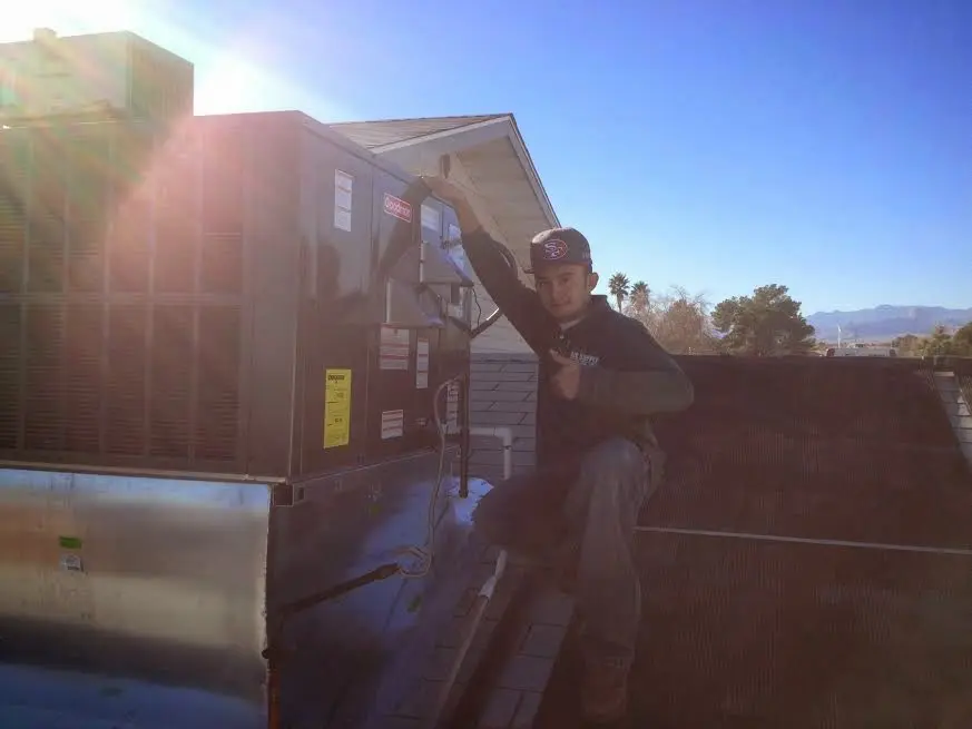 HVAC technician performing AC Tune-Up on a rooftop unit in Roanoke
